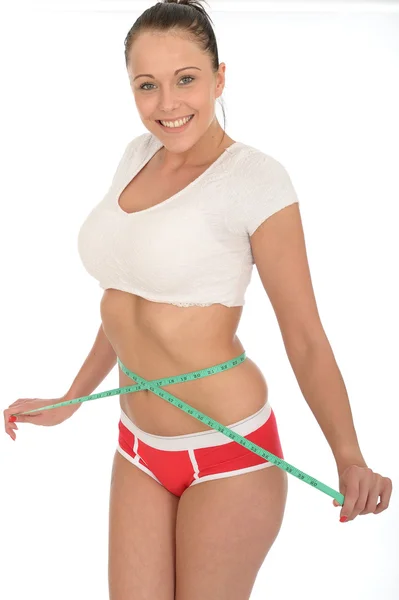 Mulher jovem saudável verificando sua perda de peso com uma fita métrica — Fotografia de Stock