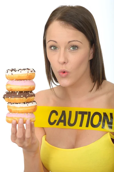 Jovem mulher atraente segurando uma pilha de rosquinhas geladas — Fotografia de Stock