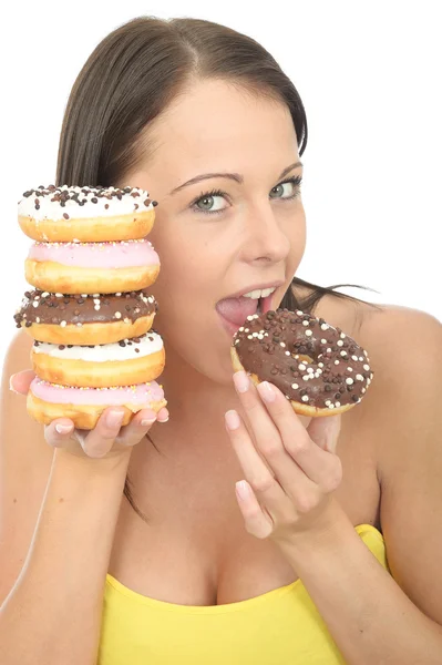Jovem mulher atraente segurando uma pilha de rosquinhas geladas — Fotografia de Stock