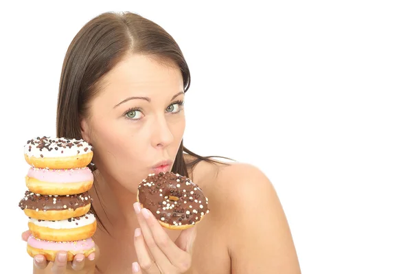 Jovem mulher atraente segurando uma pilha de rosquinhas geladas — Fotografia de Stock