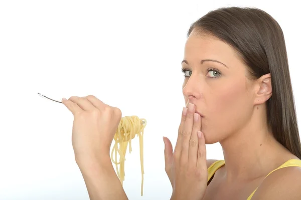 Retrato de uma jovem mulher comendo um garfo cheio de espaguete cozido — Fotografia de Stock