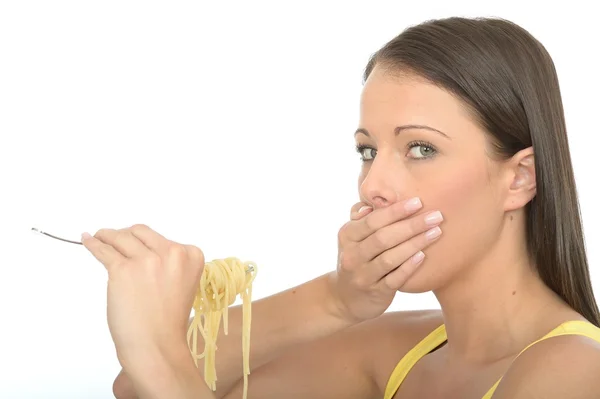 Porträt einer jungen Frau, die eine Gabel voller gekochter Spaghetti isst — Stockfoto