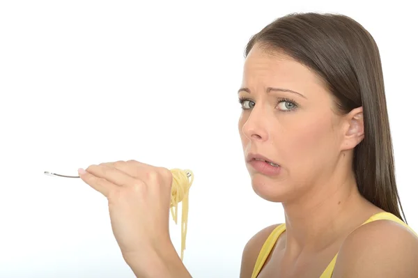 Retrato de uma jovem mulher comendo um garfo cheio de espaguete cozido — Fotografia de Stock