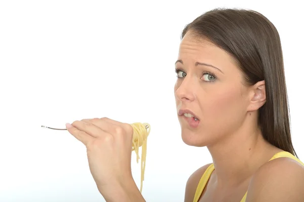 Retrato de uma jovem mulher comendo um garfo cheio de espaguete cozido — Fotografia de Stock