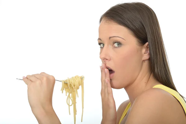 Retrato de uma jovem mulher comendo um garfo cheio de espaguete cozido — Fotografia de Stock