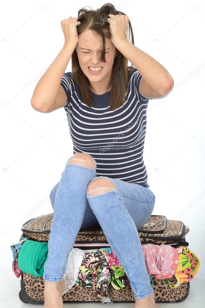 Angry Frustrated Young Woman Sitting on a Suitcase Pulling Her Hair in Temper