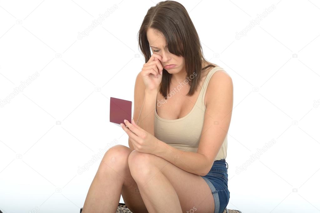 Portrait of an Attractive Young Woman Looking Concerned and Worried Looking at Her Passport Travel Documents
