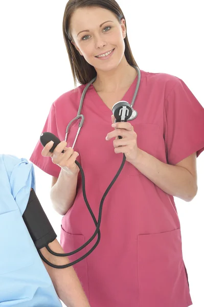 Doctora joven de unos veinte años que toma la presión arterial de una paciente femenina —  Fotos de Stock