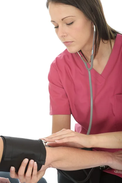 Ung kvinna läkare i tjugoårsåldern ta blodtrycket på en kvinnlig Patient Stockbild