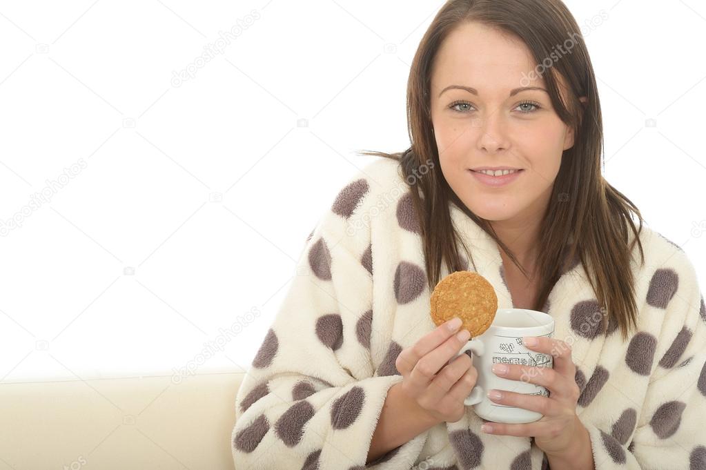 Beautiful Young Woman In A Dressing Gown Enjoying Tea And Biscuits