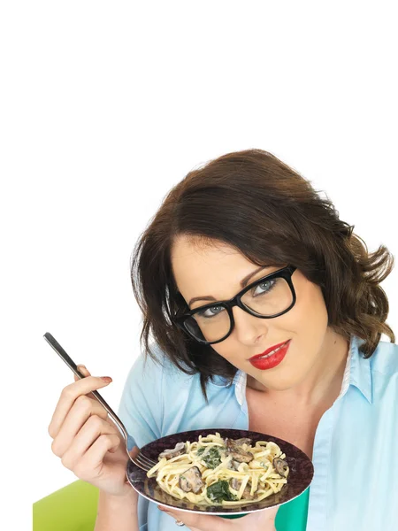 Mulher bonita em seus vinte anos segurando e comendo uma placa de Linguine vegetariano — Fotografia de Stock