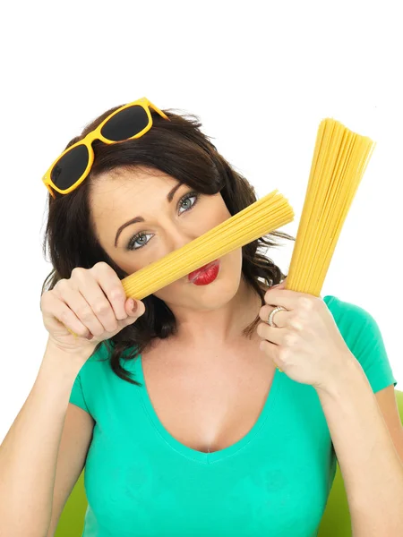 Attraktive junge Frau in ihren Zwanzigern mit einer Handvoll getrockneter Spaghetti — Stockfoto