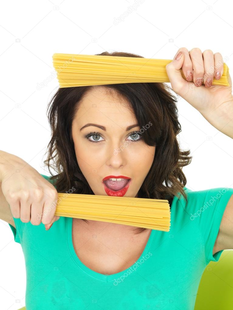 Attractive Young Woman In Her Twenties Holding Handfulls of Dried Spaghetti
