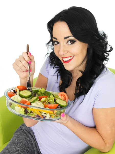 Jonge vrouw eten een frisse heldere gemengde tuin salade — Stockfoto