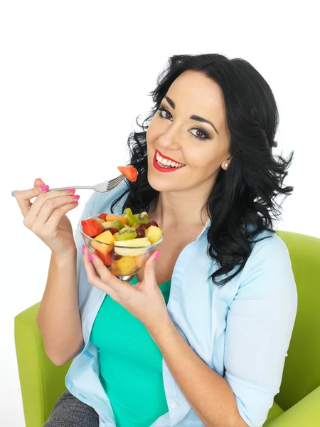 Jovem mulher comendo uma salada de frutas frescas — Fotografia de Stock