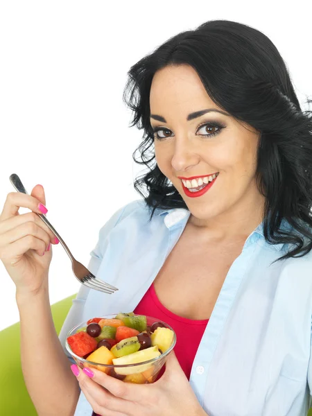 Jovem mulher comendo uma salada de frutas frescas — Fotografia de Stock