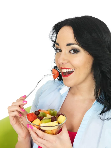 Jovem mulher comendo uma salada de frutas frescas — Fotografia de Stock