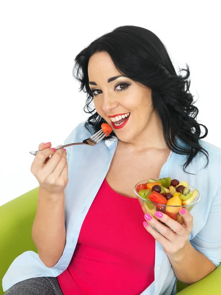 Jovem mulher comendo uma salada de frutas frescas — Fotografia de Stock