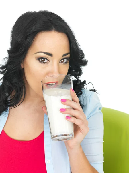 Mladá žena pije sklenici mléka — Stock fotografie