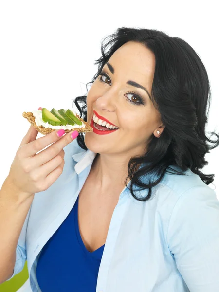 Junge Frau isst Cracker mit Quark und Avocado — Stockfoto