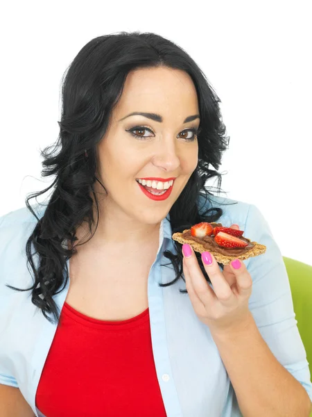 Mulher saudável comer um biscoito com espalhamento de chocolate e morangos frescos — Fotografia de Stock