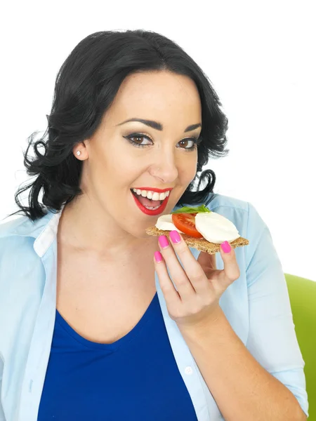 Young Woman Eating a Cracket with Mozzerella Cheese and Tomato — Stock Photo, Image