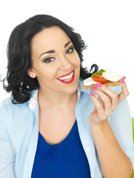 Young Woman Eating a Cracket with Mozzerella Cheese and Tomato — Stock Photo, Image