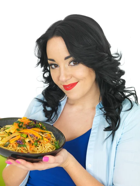 Mulher nova comendo macarrão com legumes fritos agitar — Fotografia de Stock