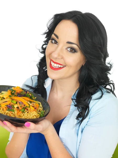 Mulher nova comendo macarrão com legumes fritos agitar — Fotografia de Stock