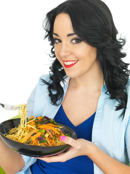 Ung kvinna äta nudlar med rör stekt grönsaker — Stockfoto