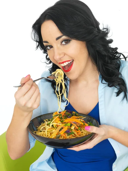 Mulher nova comendo macarrão com legumes fritos agitar — Fotografia de Stock