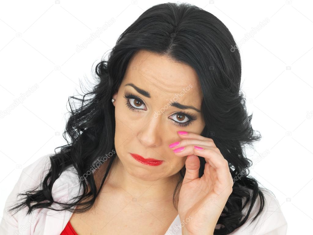 Portrait of a Beautiful Young Hispanic Woman Wiping Her Eye Looking Upset