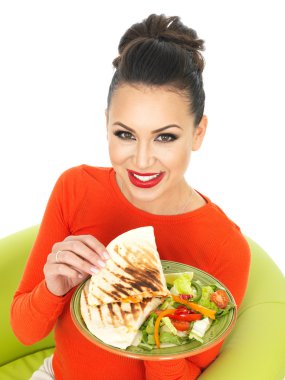 Güzel genç İspanyol kadın olarak bir parlak kırmızı Jumper bir tabak Meksika tavuk Quesadula ve salata ile