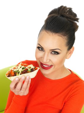 Güzel genç İspanyol kadın Chilli sığır eti Tacos ve eritilmiş peynir ile