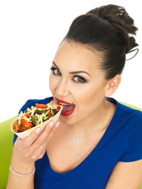 Beautiful Attractive Young Hispnanic Woman Enjoying A Soft Chilli Beef Taco With Salad