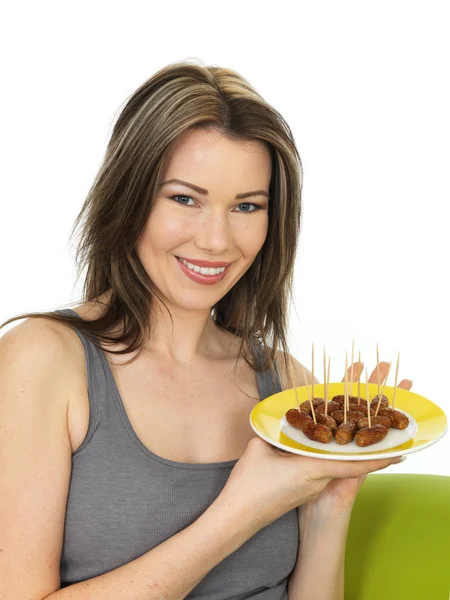 Attraktive junge Frau mit einem Teller Cocktailwürste — Stockfoto
