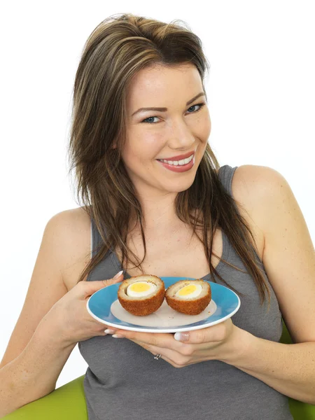 Attraente giovane donna che tiene un piatto di uova scozzesi — Foto Stock