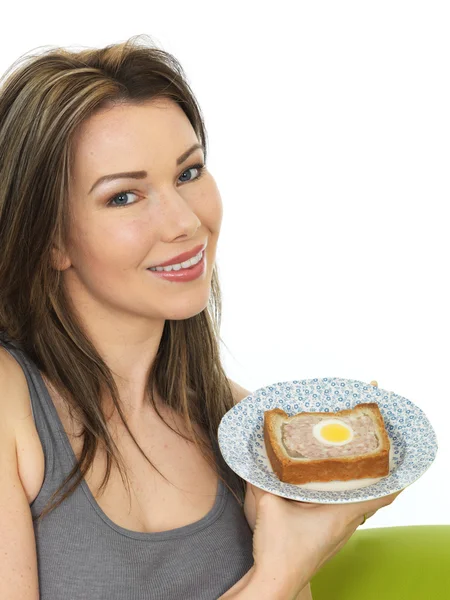 Jovem mulher atraente segurando uma fatia de torta de gala — Fotografia de Stock