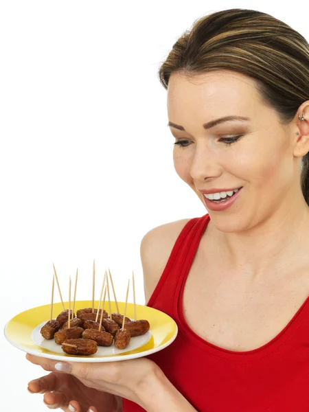 Atraktivní mladá žena drží talíř párečků — Stock fotografie