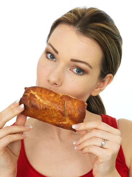 Atractiva mujer joven sosteniendo un rollo de salchicha salada caliente cocida — Foto de Stock