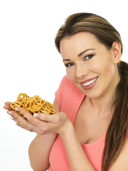 Jovem mulher atraente segurando um punhado de pretzels salgados — Fotografia de Stock