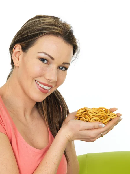 Jovem mulher atraente segurando um punhado de pretzels salgados — Fotografia de Stock