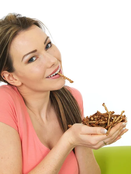 Atractiva joven mujer sosteniendo un puñado de salados Twigglets —  Fotos de Stock
