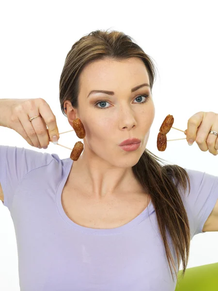 Atractiva mujer joven sosteniendo mini salchichas de cóctel en palos —  Fotos de Stock