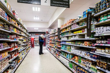 London UK, November 19 2025, Single Senior Woman Browsing Food In A Supermarket Aisle