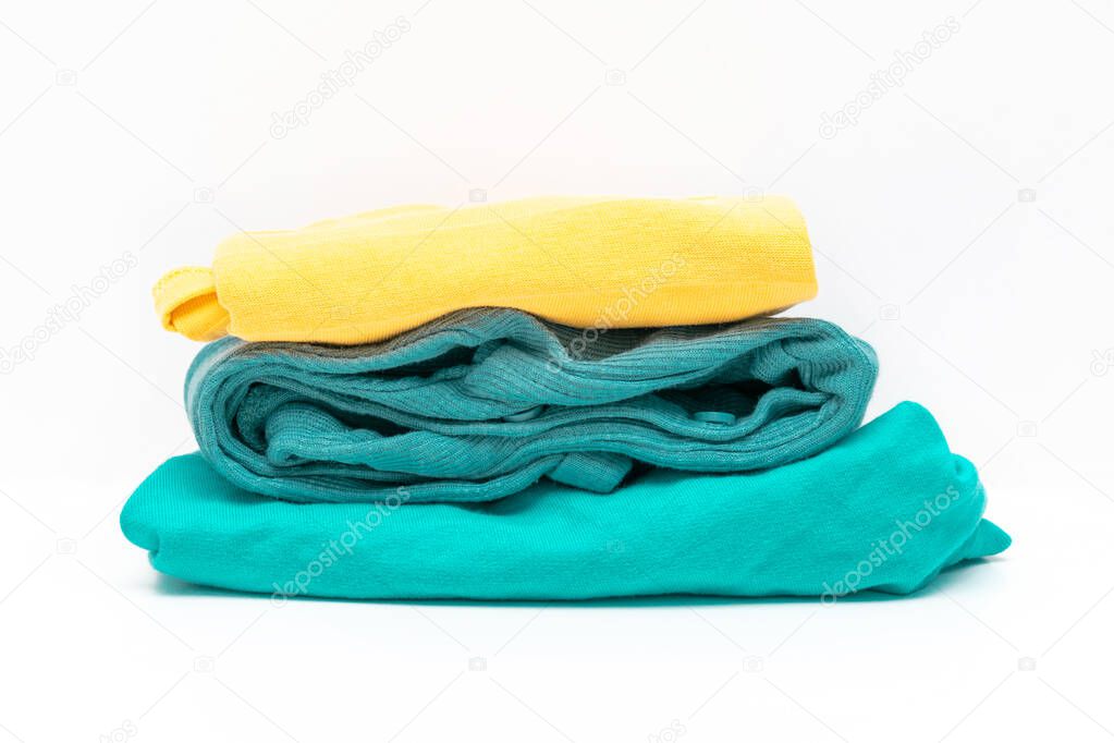 family laundry pile of colorful clothing isolated. stack of trendy color clothes close up.