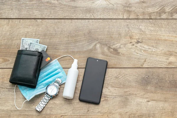医疗保护面罩 清洁剂 电话和钱包与钱在木制桌子上的复制空间 防止感染日冕病毒的概念 — 图库照片
