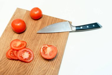 Doğranmış taze domatesleri ve bıçakları evdeki bir mutfakta tahta kesme tahtasına yakın tut..