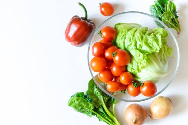 Bir kase organik ve biyo taze sebze domates, beyaz masa zemininde fotokopi alanı olan biber. Sağlıklı doğal olgun sebze konsepti. Salata için malzemeler.