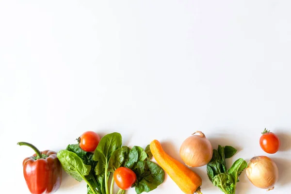 有機野菜とバイオ新鮮な野菜トマト ピーマン ニンジン タマネギはコピースペースの白い背景テーブルの上に列に並んでいます 健康的な自然な熟した菜食主義の野菜の概念 サラダ成分 — ストック写真